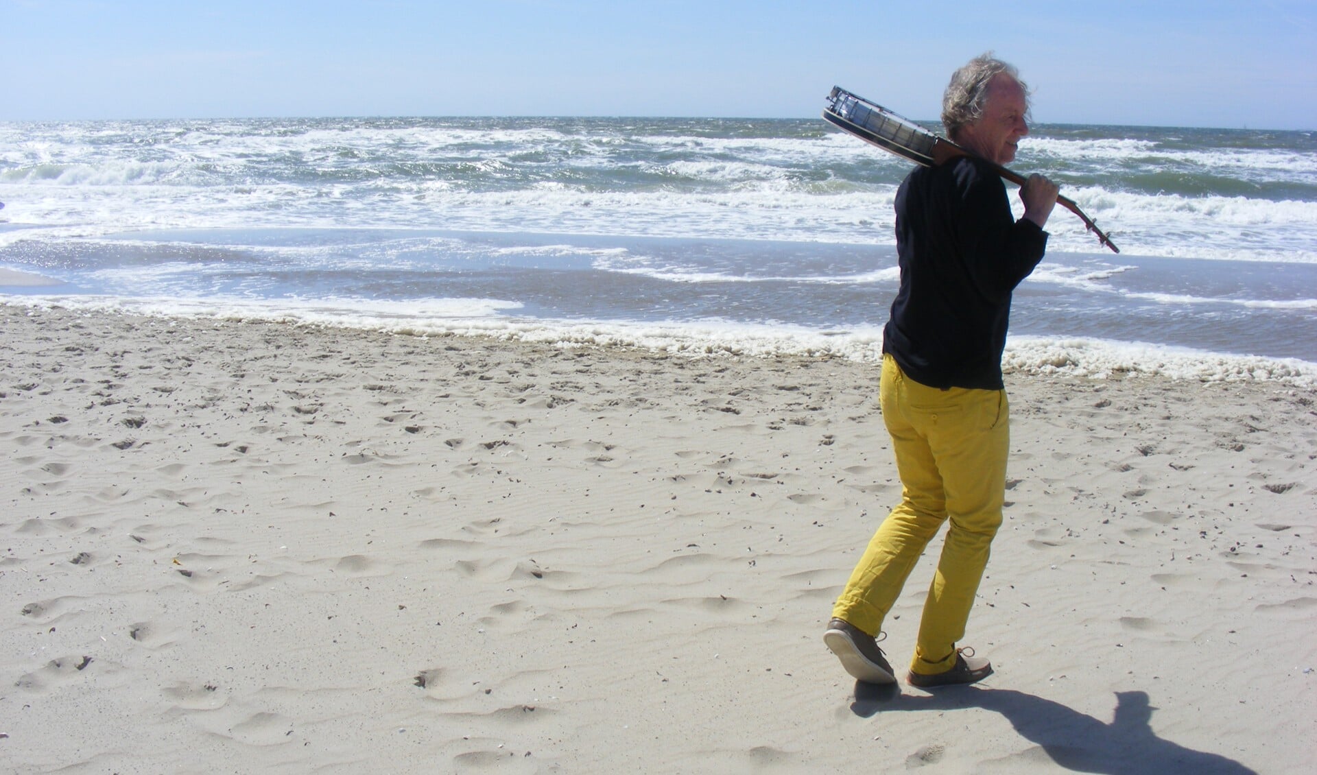 Henk van Kuijk met banjo aan zee